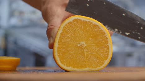 Close-up-of-cut-orange-on-a-board-in-the-kitchen-on-a-wooden-board